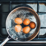 boiling eggs in a pan on the stove